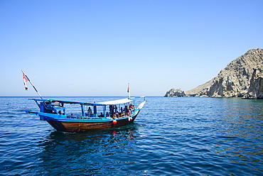 Tourist boat in form of a dhow sailing in the Khor ash-sham fjord, Musandam, Oman, Middle East