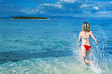 Woman running in the water, Beachcomber Island, Mamanucas Islands, Fiji, South Pacific, Pacific