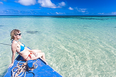 Woman relaxing on little motor boat, Haapai, Haapai Islands, Tonga, South Pacific, Pacific