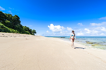 Woman walking on a white sand beach on a little islet in Haapai, Haapai Islands, Tonga, South Pacific, Pacific