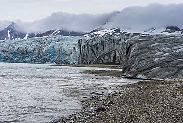 Gravel beach before a huge glacier in Hornsund, Svalbard, Arctic