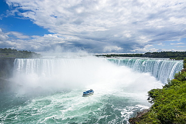 Tourist boat in the mist of the Horseshoe Falls (Canadian Falls), Niagara Falls, Ontario, Canada, North America