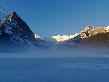 Sunrise on Mount Victoria on Lake Louise with mist rising on frozen lake, Banff National Park, UNESCO World Heritage Site, Alberta, Rocky Mountains, Canada, North America