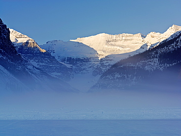 Sunrise on Mount Victoria on Lake Louise with mist rising on frozen lake, Banff National Park, UNESCO World Heritage Site, Alberta, Rocky Mountains, Canada, North America