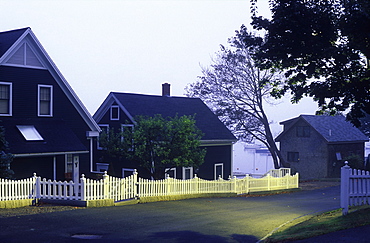 Homes with picket fences along a sreet illuminated at dawn, Camden, Maine, New England, United States of America, North America