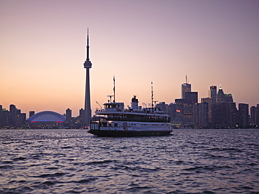 Toronto Islands ferry heading towards the city at dusk, Toronto, Ontario, Canada, North America