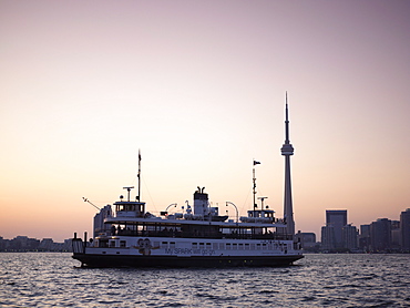 Toronto Islands ferry heading towards the city at dusk, Toronto, Ontario, Canada, North America