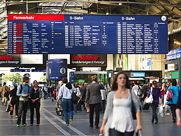 Train schedules and people inside the Hauptbahnhof, city's main railway station, Zurich, Switzerland, Europe