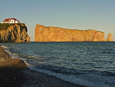 Perce Rock illuminated at sunset at high tide and the Gulf of St. Lawrence, Perce, Gaspesie, Quebec, Canada, North America