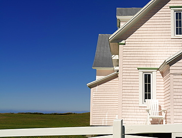 Pink house and with white fence against a blue sky, Riviere-la-Madeleine, Gaspesie, Quebec, Canada, North America