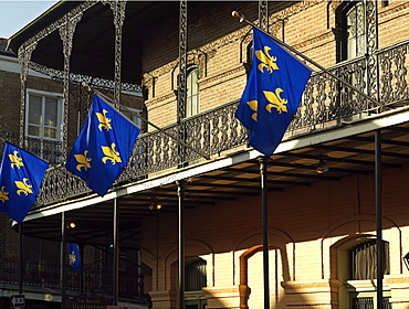 French Quarter building with wrought iron balconies and fleurs de lys flags, New Orleans, Louisiana, United States of America, North America