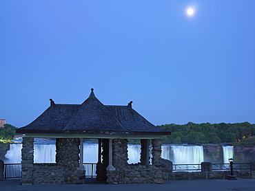 Stone pavilion with the American Falls illuminated at dusk with moon rise, Niagara Falls, Ontario, Canada, North America