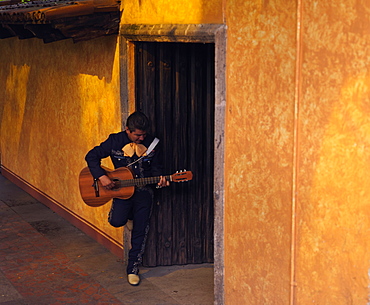 Musician playing guitar in an open doorway, Tequila, Jalisco, Mexico, North America