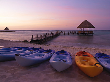 Kayaks on the beach and pier with palapa jutting out into the water from the beach, Mayan Riviera, Akumal, Yucatan, Quintana Roo, Mexico, North America