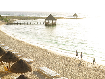 Seaside beach scene with palapa and beach chairs with bright sunlight reflecting off of the water, Mayan Riviera, Akumal, Yucatan, Quintana Roo, Mexico, North America