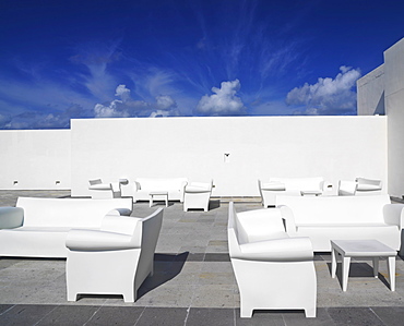 White chairs and white couches against a white wall and blue sky in a surreal setting, Mayan Riviera, Akumal, Yucatan, Quintana Roo, Mexico, North America