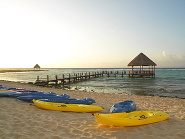 Kayaks on the beach and pier with palapa jutting out into the water from the beach, Mayan Riviera, Akumal, Yucatan, Quintana Roo, Mexico, North America