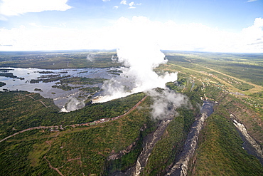 Mist rises above the Victoria Falls waterfall (Mosi-oa-Tunya), UNESCO World Heritage Site on the border of Zimbabwe and Zambia, Africa