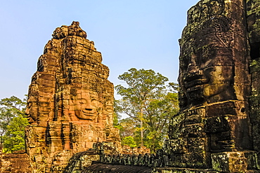 Towers and three of the 216 smiling sandstone faces at 12th century Bayon temple in Angkor Thom walled city, Angkor, UNESCO World Heritage Site, Siem Reap, Cambodia, Indochina, Southeast Asia, Asia