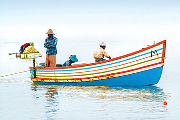 Fishermen in colourful boat on the Arabian Ocean just off popular Marari Beach, Mararikulam, Alappuzha (Alleppey), Kerala, India, Asia