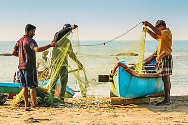 Fishermen cleaning net at beautiful Kizhunna Beach, south of Kannur on the Keralan north coast, Kizhunna, Kannur, Kerala, India, Asia