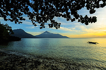 Sunset view from Kalea Beach of canoe and Karangetang volcano, Kalea, Siau Island, Sangihe Archipelago, North Sulawesi, Indonesia, Southeast Asia, Asia