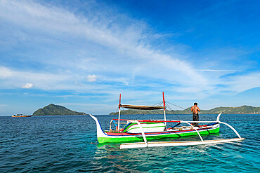 Outrigger canoe off Bahuis Island and the southern tip of Siau, Siau Island, Sangihe Archipelago, North Sulawesi, Indonesia, Southeast Asia, Asia