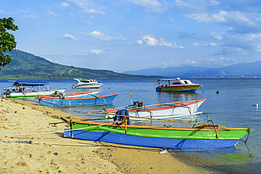 Outrigger canoes and launches at this coral fringed holiday island and scuba diving destination, Bunaken Island, Sulawesi, Indonesia, Southeast Asia, Asia