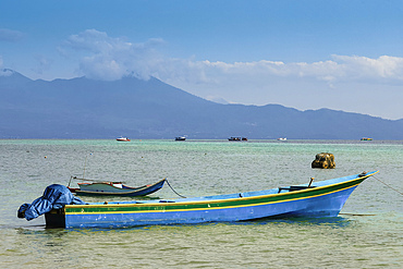 Small boats moored with the mainland beyond, off this coral fringed holiday and scuba diving destination, Bunaken Island, Sulawesi, Indonesia, Southeast Asia, Asia