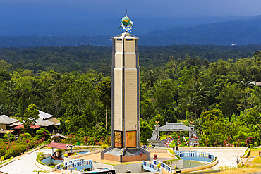 The world peace themed tower and dark stormy sky at this tourist park with worship houses of five major religions and volcanic fumarole field,. Bukit Kasih, Minahasa, North Sulawesi, Indonesia, Southeast Asia, Asia