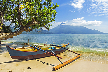 Outrigger canoe moored on Kalea Beach with active Karangetang volcano beyond, Kalea, Siau Island, Sangihe Archipelago, North Sulawesi, Indonesia, Southeast Asia, Asia