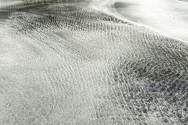 Tidal sorting of white sand & darker minerals into patterns at the west coast Talisker Bay beach, known as a 'white & black sand beach'. An SSSI for it's Tertiary basalt lava geology. Talisker Bay, Carbost, Skye, Inner Hebrides, Skye, Scotland, UK