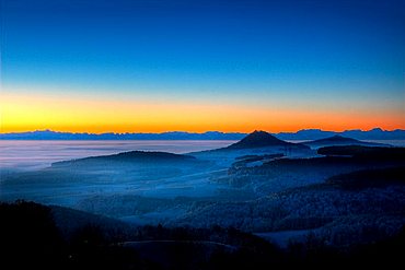 Dawn atmosphere, mist-covered Hegau volcanic range, with only the highest peaks Hohenhewen and Hohenstoffel exposed, Swiss Alps in background, Hegau, Baden-Wuerttemberg, Germany, Europe