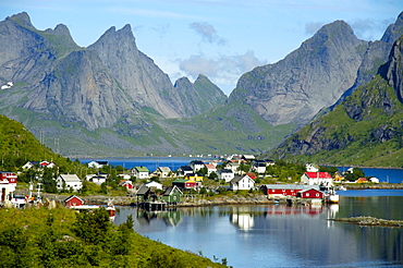 Rough mountains and houses reflect in the fjord Reine Moskenesoya Lofoten Norway