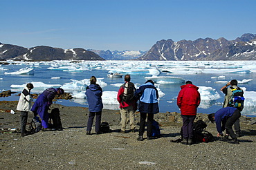 People watch ice pack and icebergs in Ammassalik Fjord near Kulusuk Eastgreenland