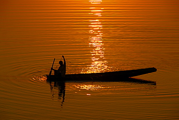 Sundown fisherman is fishing in his fishing boat in the Mekong River Vientiane Laos