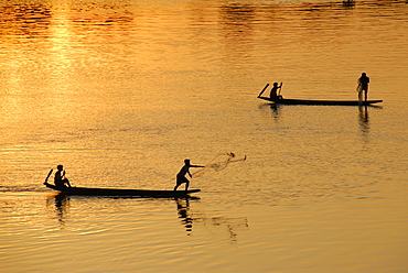 Sunset fishermen in boats throwing nets on the Mekong River Muang Khong Si Phan Don Laos