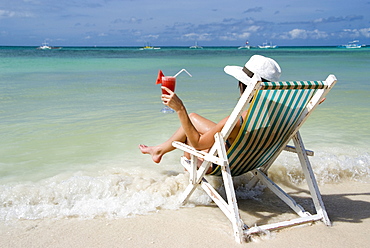 Woman with cocktail enjoys holidays at sea