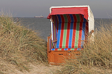 DEU, Federal Republic of Germany, Wangerland, Hooksiel, dunes with empty beach chair North Sea, Jadebusen