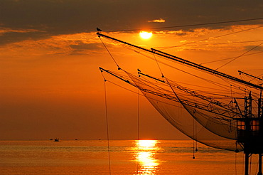 Fishing nets hanging up to dry above the sea at sunrise, Veneto, Italy