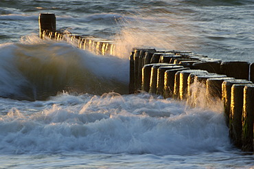 Waves breaking at a groyne at dusk Baltic Sea Germany