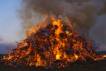 Easter eve bonfire burning at dusk, Germany