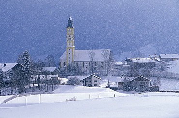 Snow falling over St. Nicholas Church, Pfronten, East Allgaeu, Bavaria, Germany, Europe