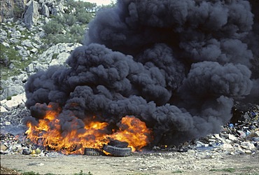 Fire in waste dump with car tires - smoke emission Spain