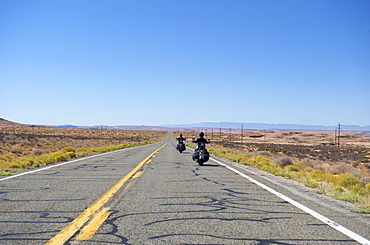 Two motorcyclists on a highway between Utah and Arizona, USA