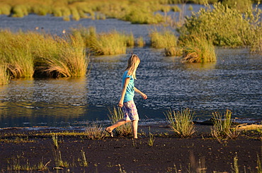 Girl wading in a wet bog, Stammbecken Moor, former Nicklheim peat works, Rosenheim, Bavaria, Germany, Europe