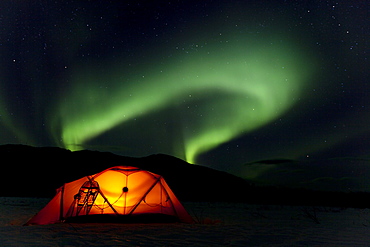 Illuminated expedition tent and traditional wooden snow shoes, Northern Lights, Polar Lights, Aurora Borealis, green, near Whitehorse, Yukon Territory, Canada