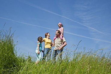 Family standing relaxed in a flower meadow