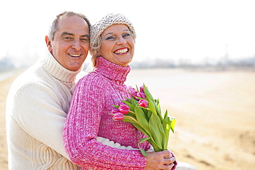 Senior couple holding tulips in their hands