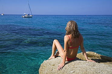 Woman sunbathing on a rock, Spiaggia di San Andrea, Elba, Italy, Europe